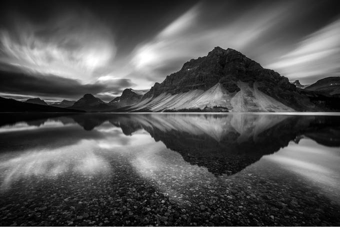 Long exposure shot of Bow Lake during sunrise. I drove all night and slept in my truck until sunrise to get this shot. I was fortunate to have no wind to get the still water and great clouds. Used a Sony A7Rii with a Voigtlander 15mm Heliar iii. by beautifulpixels1 - Black And White Landscapes Photo Contest